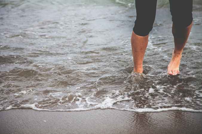 man standing on black sand